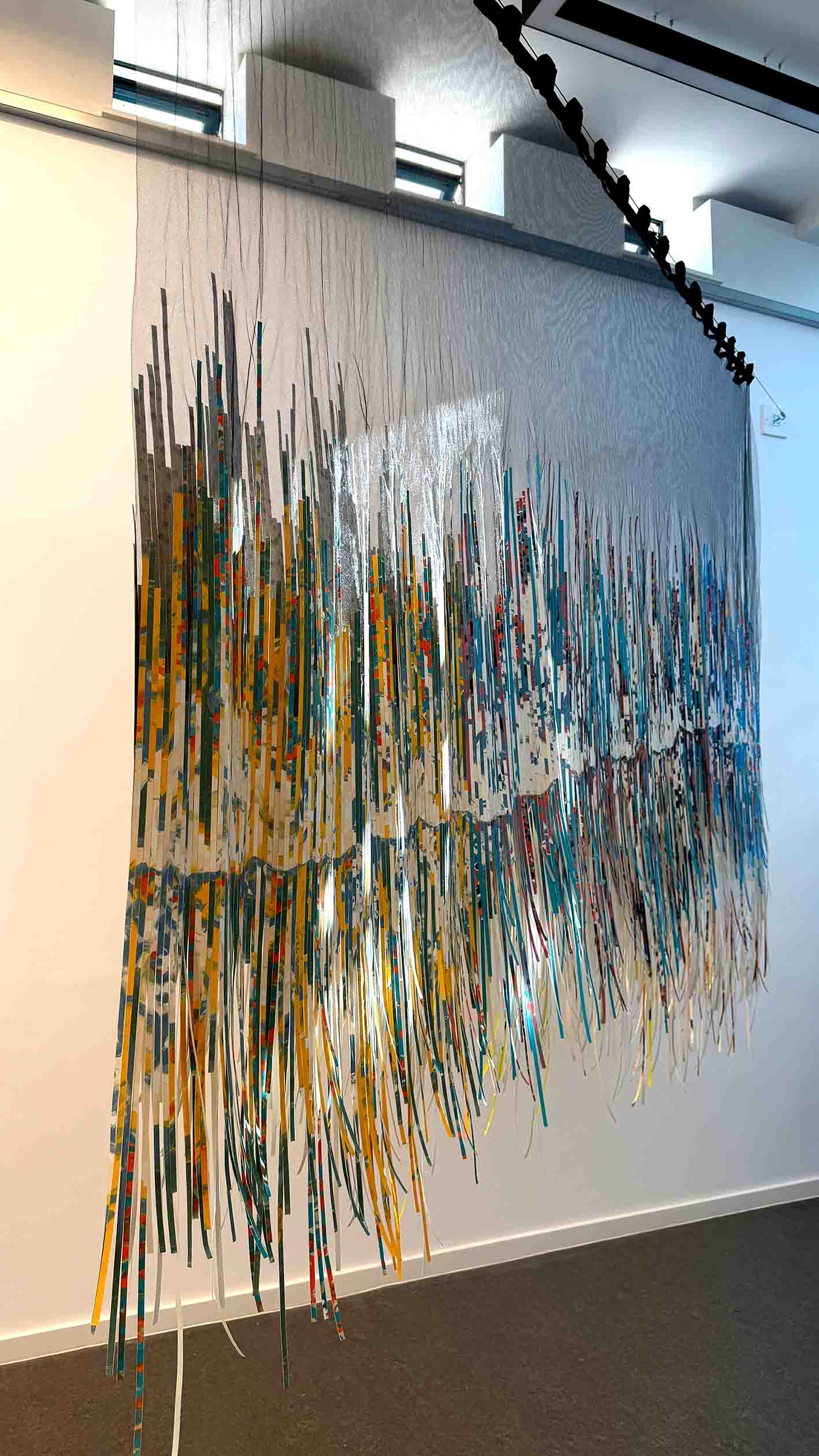 Suspended piece of artwork made from fabric and paper