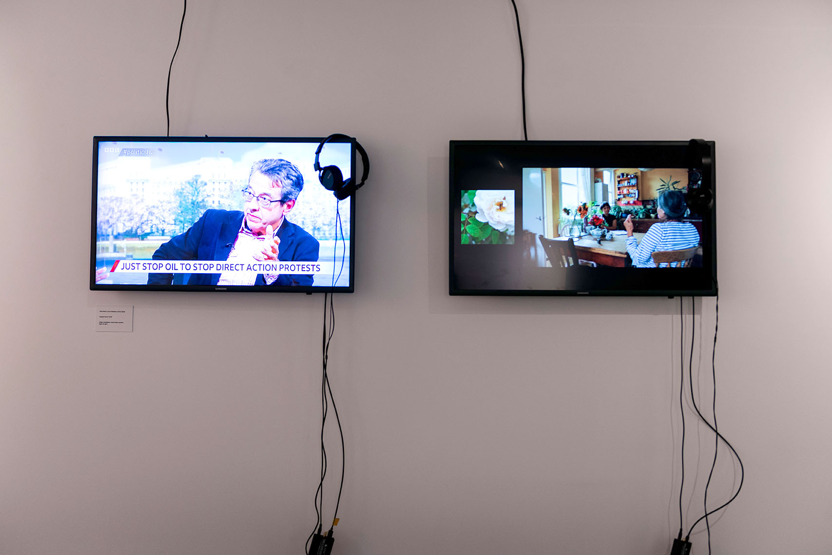 Two TV's with headphones and videos of people