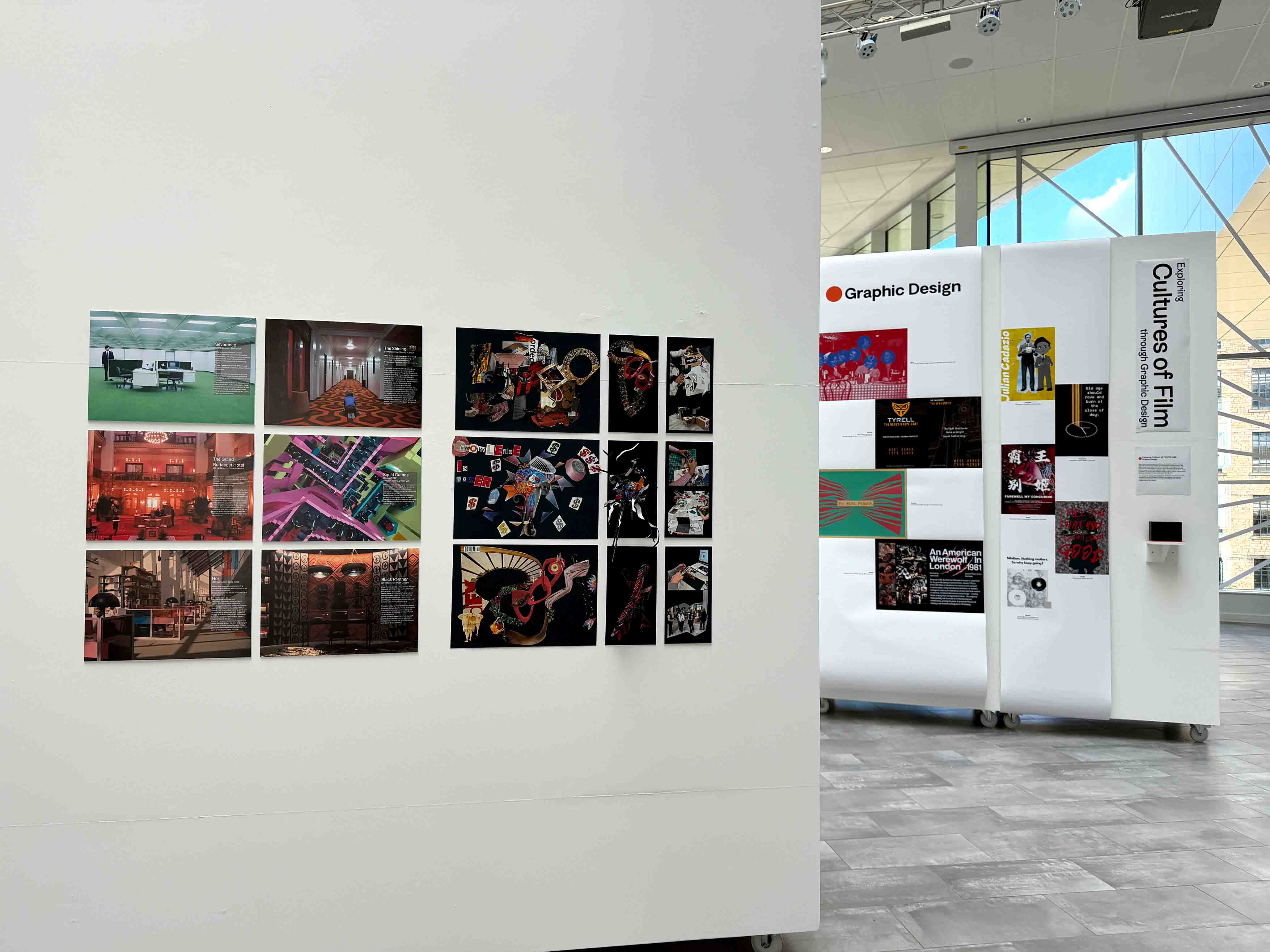 An exhibition of work on white walls in a large atrium space