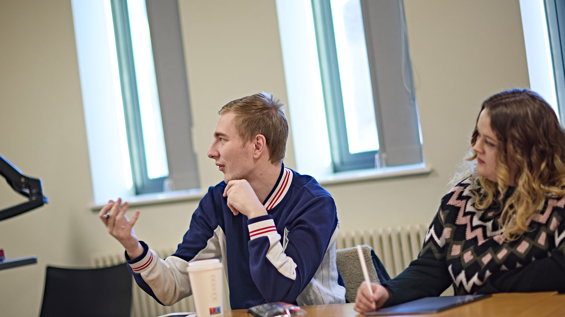 Two students in classroom looking at the teacher