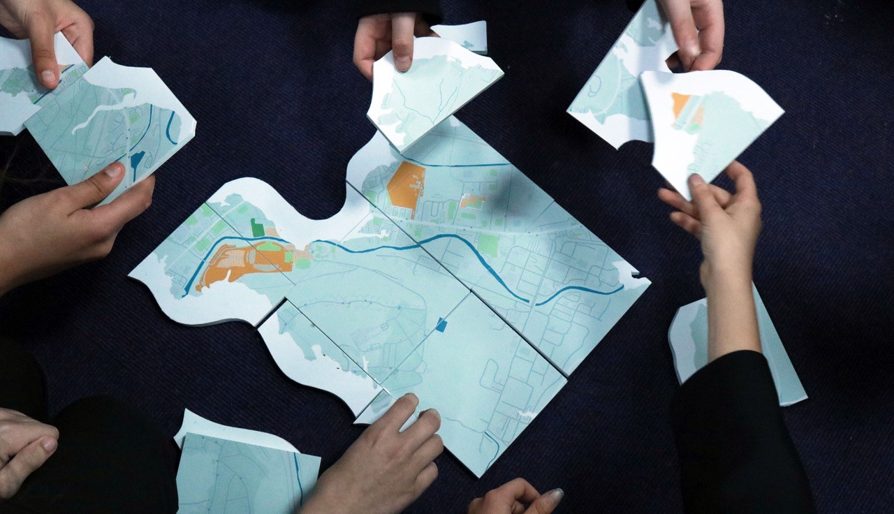 Many hands constructing a map