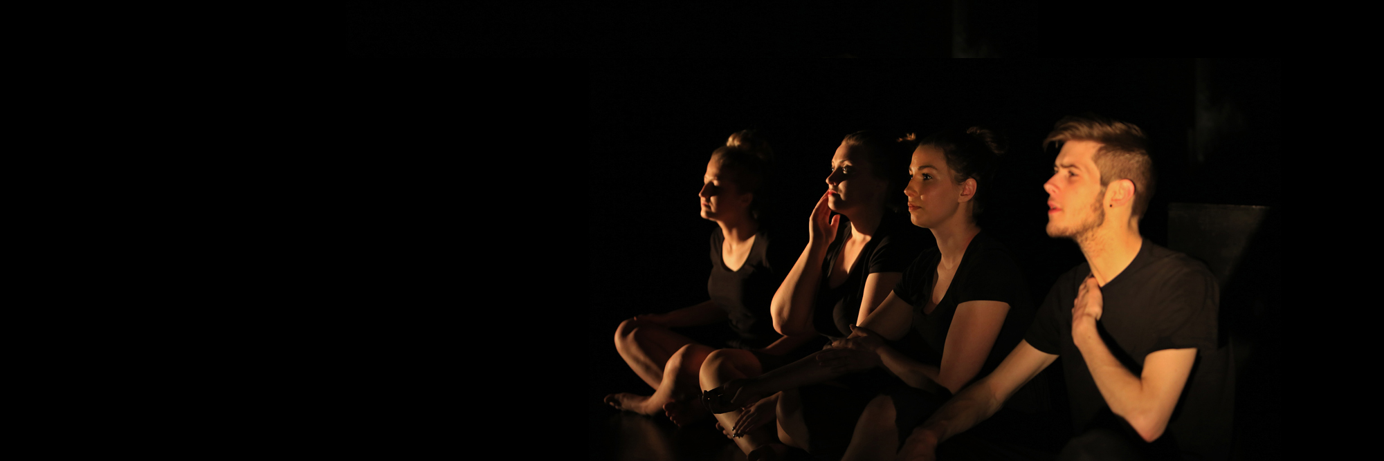 Drama students on a dimmed stage
