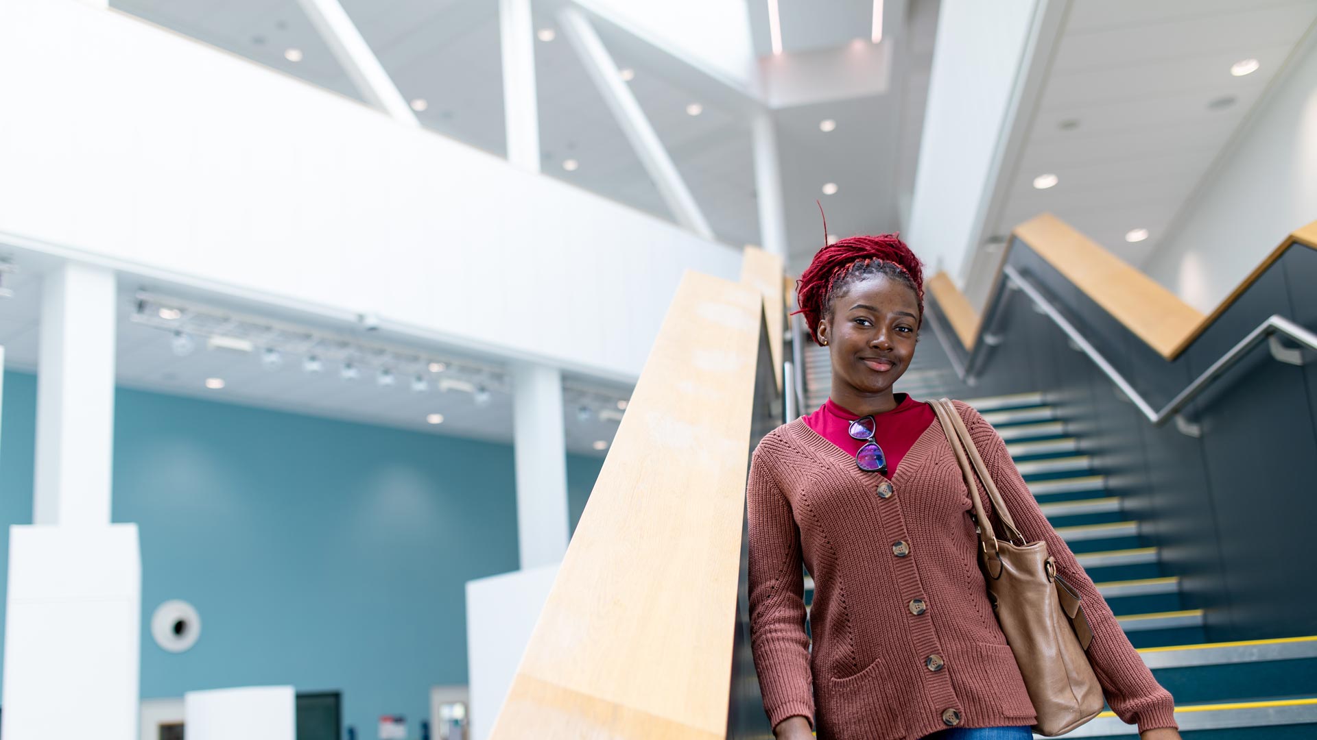 A student walking down a staircase in the Barbara Hepworth