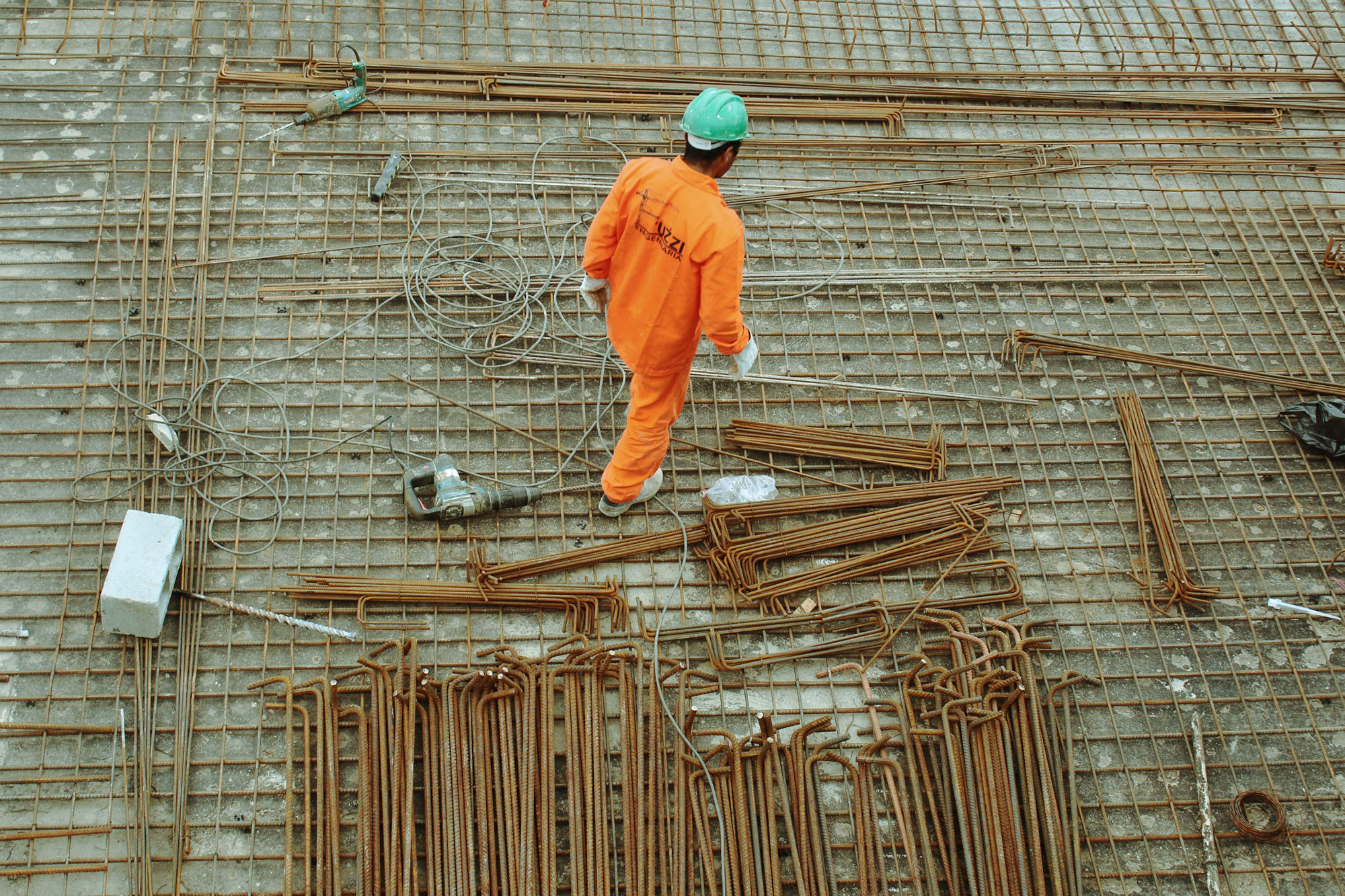 Photo of a person on construction site, wearing high visibility clothing and a hard hat